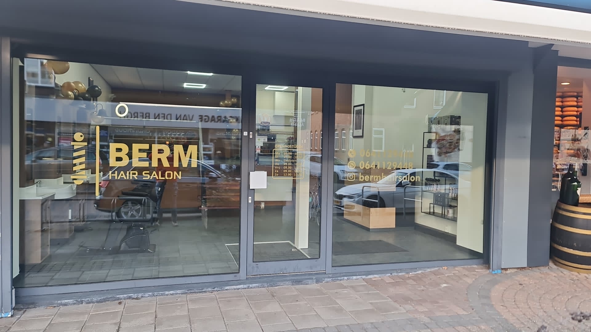 De winkelpui van Berm Hairsalon aan de Bermweg 35 met het gouden BERM HAIR SALON logo op het raam